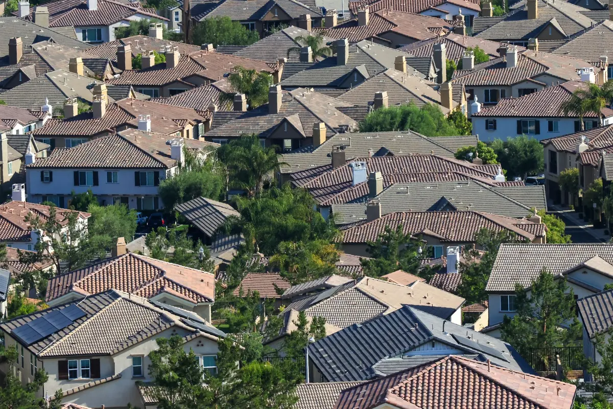 An aerial view across a suburban neighborhood of tiled and shingled roofs, the kind of street a service area page is written for